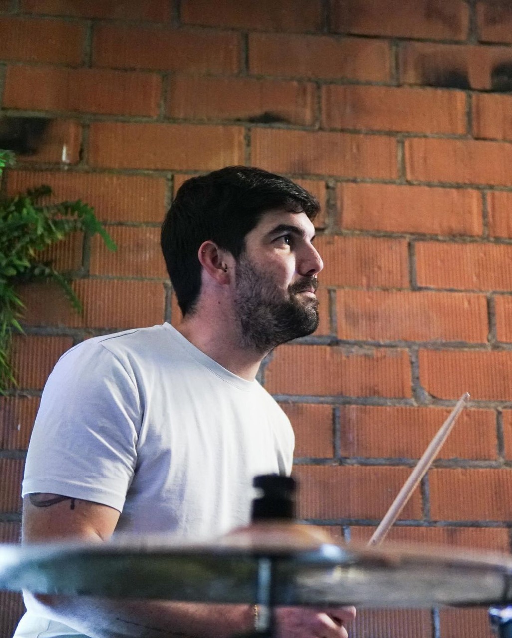 Bateria de Col·lectiu Desembre en un concert, amb una paret de maons al fons